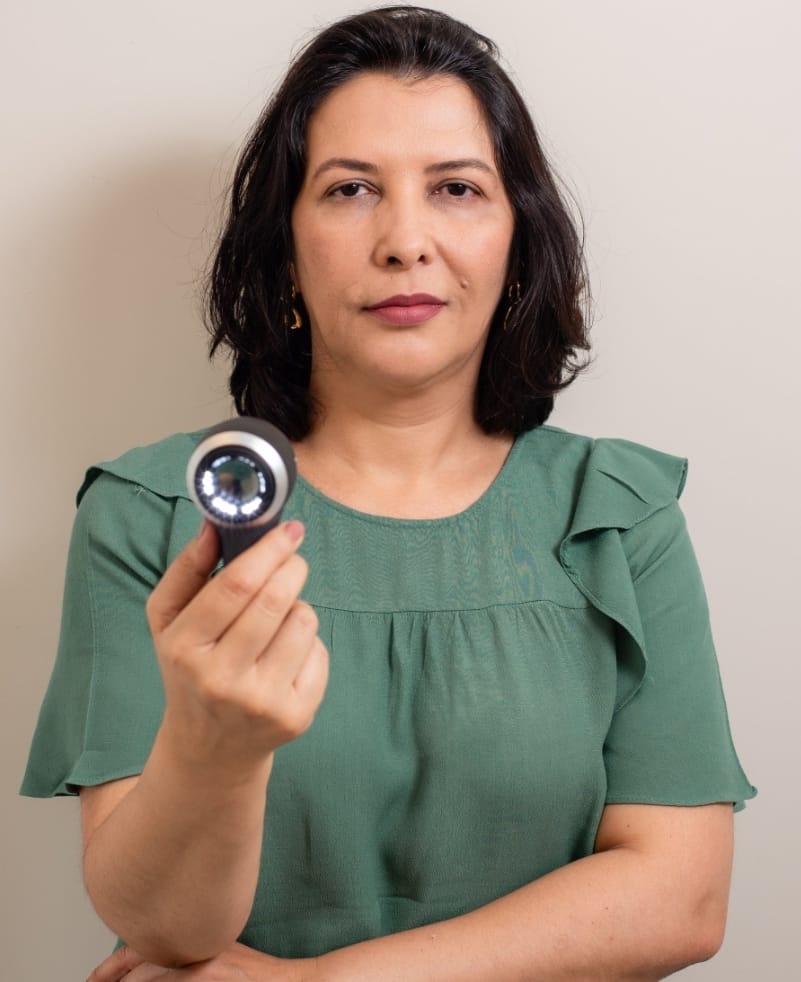 Dra. Sirenice tem o dermatoscópio como alinhado no exame do couro cabeludo e dos cabelos.